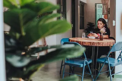 a woman sitting at a table in a restaurant at Centro Hostel Medellin in Medellín