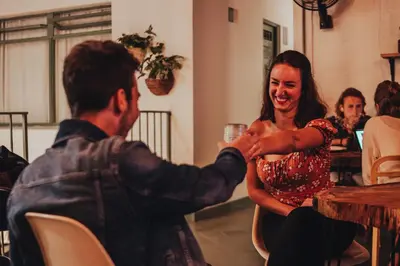 a man giving a woman a glass of wine at Centro Hostel Medellin in Medellín
