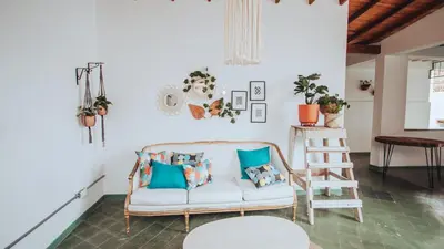 a living room with a white couch and blue pillows at Centro Hostel Medellin in Medellín