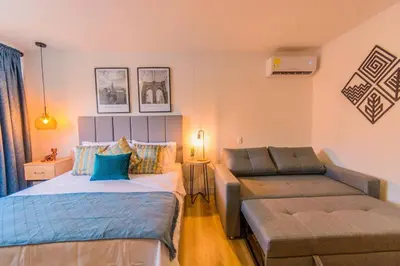 a bedroom with two beds and a couch at Luxury Suite in El Poblado Co-Work, Gym, Fast WiFi in Medellín