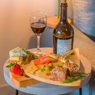 a plate of food and a bottle of wine and a glass at Luxury Suite in El Poblado Co-Work, Gym, Fast WiFi in Medellín