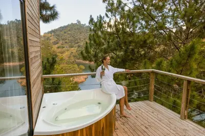 a woman sitting in a bath tub on a balcony at Cabañas Refugio Himalaya in Guatapé