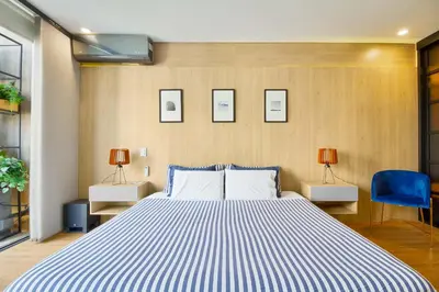 a bedroom with a large bed with a blue chair at Energy 801 in Medellín