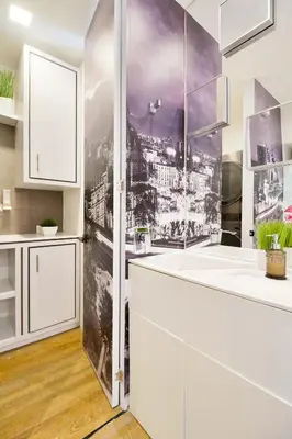 a kitchen with white cabinets and a wall mural of a city at Energy 801 in Medellín