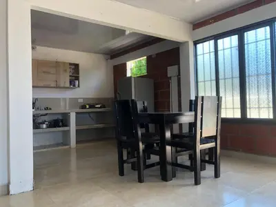 a kitchen with a table and chairs and a refrigerator at CASA EN DORADAL in Puerto Triunfo