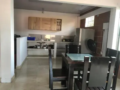 a kitchen with a table and chairs and a refrigerator at CASA EN DORADAL in Puerto Triunfo