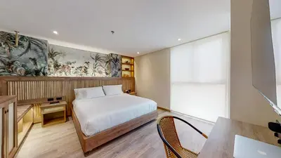 a bedroom with a bed and a desk and a table at Origen Hotel Boutique in Medellín
