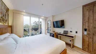 a bedroom with a bed and a desk with a laptop at Origen Hotel Boutique in Medellín