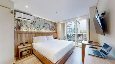 a bedroom with a bed and a laptop and a window at Origen Hotel Boutique in Medellín