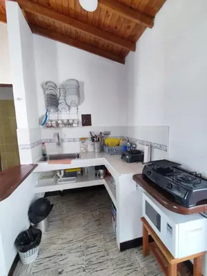 a white kitchen with a counter and a sink at Cabaña 52 en la Aldea Doradal Santorini Colombiano in Doradal