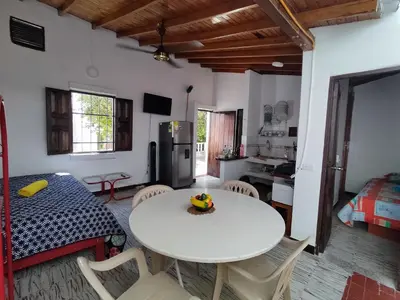 a kitchen and dining room with a white table and chairs at Cabaña 52 en la Aldea Doradal Santorini Colombiano in Doradal