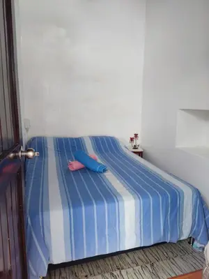 a blue and white bed with two pillows on it at Cabaña 52 en la Aldea Doradal Santorini Colombiano in Doradal
