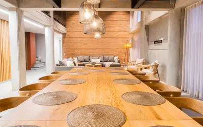 a long wooden table in a room with a couch at Topá House in Medellín