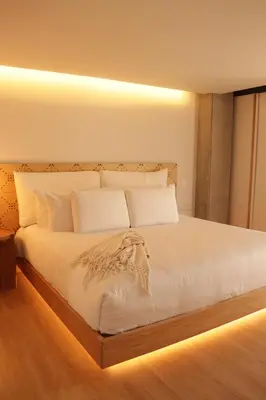 a bedroom with a white bed with lights on it at Topá House in Medellín