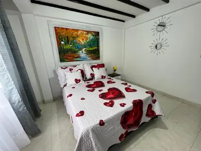 a bedroom with a bed with red roses on it at APARTAMENTO CON VISTA A LAS MONTAÑAS CAPACIDAD 6 PERSONAS SECTOR VILLAMARIA in Villamaría