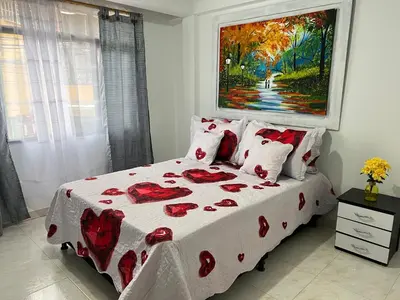 a bedroom with a bed with red roses on it at APARTAMENTO CON VISTA A LAS MONTAÑAS CAPACIDAD 6 PERSONAS SECTOR VILLAMARIA in Villamaría