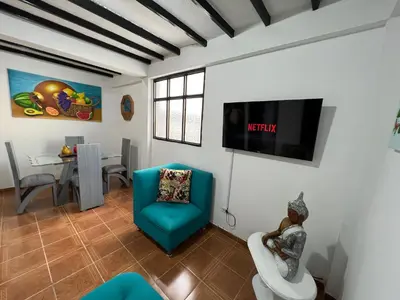 a living room with a tv on a wall at APARTAMENTO CON VISTA A LAS MONTAÑAS CAPACIDAD 6 PERSONAS SECTOR VILLAMARIA in Villamaría