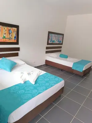 two twin beds in a room with a tile floor at Hotel Villa Alicia in San Jerónimo