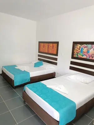 a group of three beds in a room at Hotel Villa Alicia in San Jerónimo