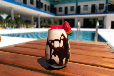 a chocolate shake with strawberries on a table next to a pool at Hotel Villa Alicia in San Jerónimo