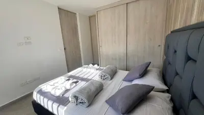 a bedroom with a bed with towels and pillows at Apto Moderno, Ubicacion Perfecta, a media calle del Malecon y Embalse, a 8 min de la Piedra del Peñol in Guatapé