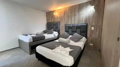 a room with two beds in a room at Apto Moderno, Ubicacion Perfecta, a media calle del Malecon y Embalse, a 8 min de la Piedra del Peñol in Guatapé