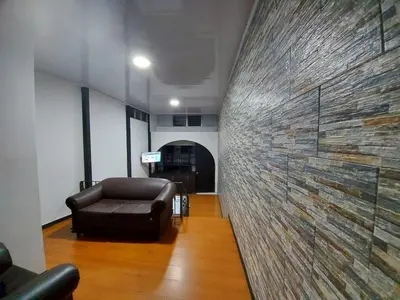 a living room with a leather couch and a wall at Apartaestudio2 Sector Cable-Estadio in Manizales