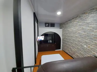 a living room with a couch and a brick wall at Apartaestudio2 Sector Cable-Estadio in Manizales