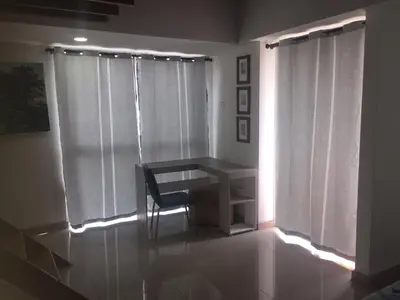 a table and a chair in a room with a window at Apartamento Lof, Dúplex, iluminado, bueno , céntrico y bien ubicado en Laureles estadio in Medellín