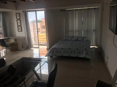 a bedroom with a bed and a large window at Apartamento Lof, Dúplex, iluminado, bueno , céntrico y bien ubicado en Laureles estadio in Medellín
