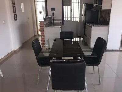 a dining room with a glass table and black chairs at Apartamento Lof, Dúplex, iluminado, bueno , céntrico y bien ubicado en Laureles estadio in Medellín