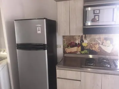 a kitchen with a refrigerator and a microwave at Apartamento Lof, Dúplex, iluminado, bueno , céntrico y bien ubicado en Laureles estadio in Medellín
