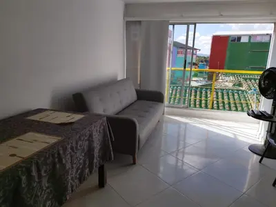 a living room with a couch and a large window at Apartamento Centro Guatapé, parque y embalse in Guatapé