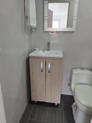 a bathroom with a sink and a toilet and a mirror at Apartamento Centro Guatapé, parque y embalse in Guatapé