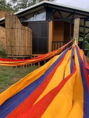 a colorful hammock in front of a house at Cabaña Glamping Los Canarios San Rafael, Antioquia in San Rafael