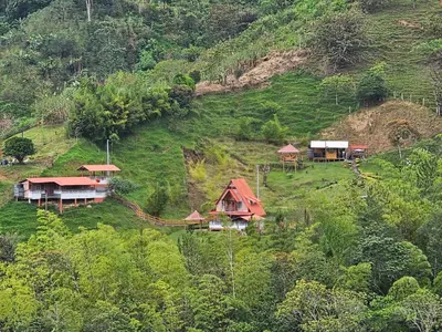 a group of houses on a hill with trees at Cabaña Glamping Los Canarios San Rafael, Antioquia in San Rafael