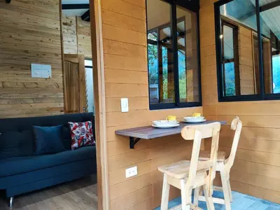 a small table and two chairs in front of a house at Cabaña Glamping Los Canarios San Rafael, Antioquia in San Rafael