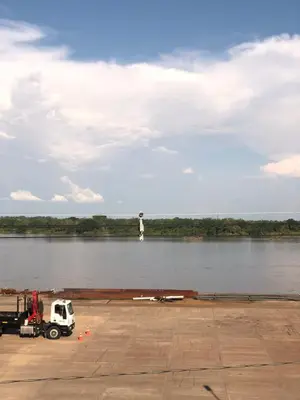 a man is standing on a dock on a river at HOTEL DORADO PUERTO BERRIO in Puerto Berrío