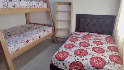 a bedroom with two bunk beds with red flowers at AMPLIO APARTAMENTO AMOBLADO SECTOR LAURELES-ESTADIO Paris in Medellín