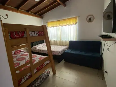 a bedroom with two bunk beds and a couch at AMPLIO APARTAMENTO AMOBLADO SECTOR LAURELES-ESTADIO Paris in Medellín