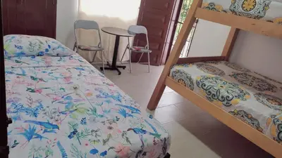 a bedroom with two bunk beds and a table and chairs at AMPLIO APARTAMENTO AMOBLADO SECTOR LAURELES-ESTADIO Paris in Medellín