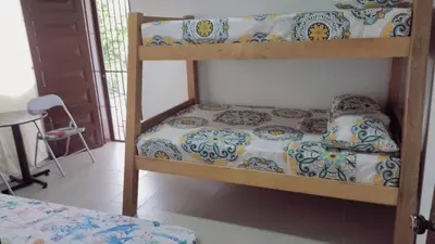 a bedroom with two bunk beds and a table at AMPLIO APARTAMENTO AMOBLADO SECTOR LAURELES-ESTADIO Paris in Medellín