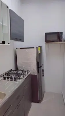 a kitchen with a stove and a refrigerator at AMPLIO APARTAMENTO AMOBLADO SECTOR LAURELES-ESTADIO Paris in Medellín