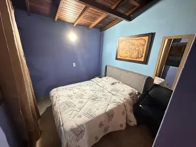 a small bedroom with a bed in a blue wall at Hostel Urban City Medellin in Medellín