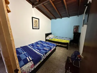 a bedroom with two beds and a chair in it at Hostel Urban City Medellin in Medellín