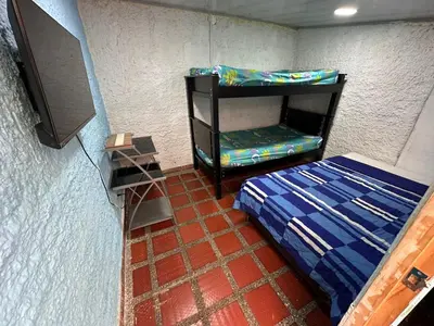 a small bedroom with a bed and a tv at Hostel Urban City Medellin in Medellín