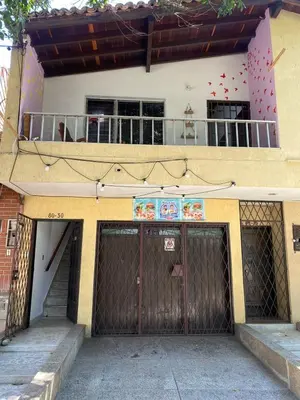 a building with two garage doors and a balcony at Hostel Urban City Medellin in Medellín