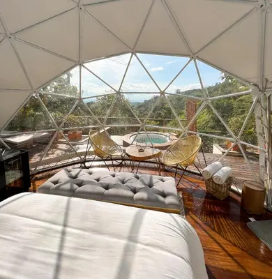 a room with a bed and chairs and a large window at Nazca Glamping in Villamaría