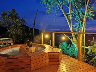 a child sitting in a hot tub on a deck at Nazca Glamping in Villamaría