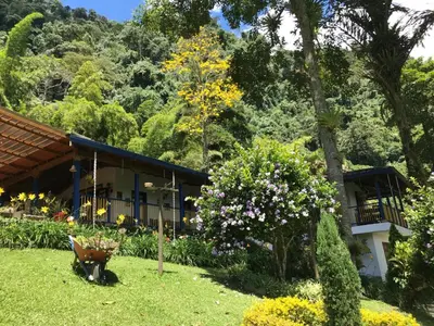 a garden in front of a house with flowers at FINCA HOTEL CARMONIA DEL BOSQUE in Venecia